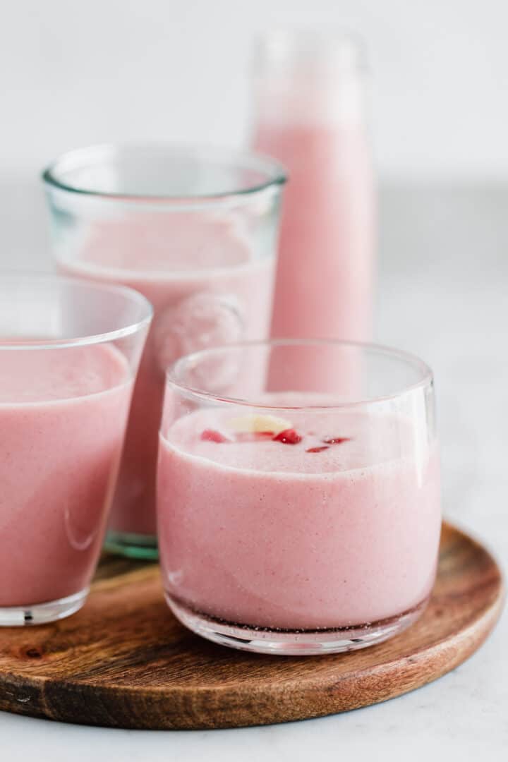 strawberry smoothie in glassed on a wooden board