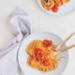 one pot pasta served in two blue plates with golden cutlery