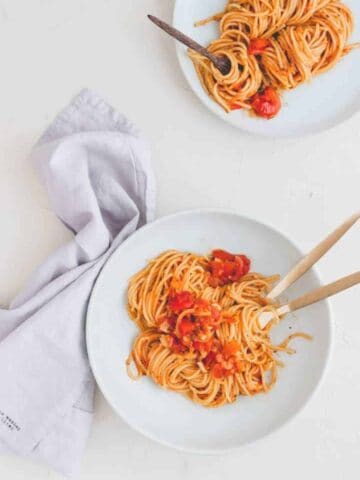 one pot pasta rezept serviert in zwei blauen tellern mit goldigem besteck
