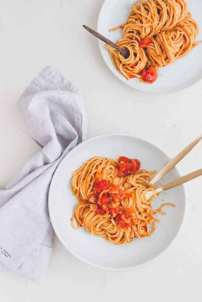 one pot pasta served in two blue plates with golden cutlery