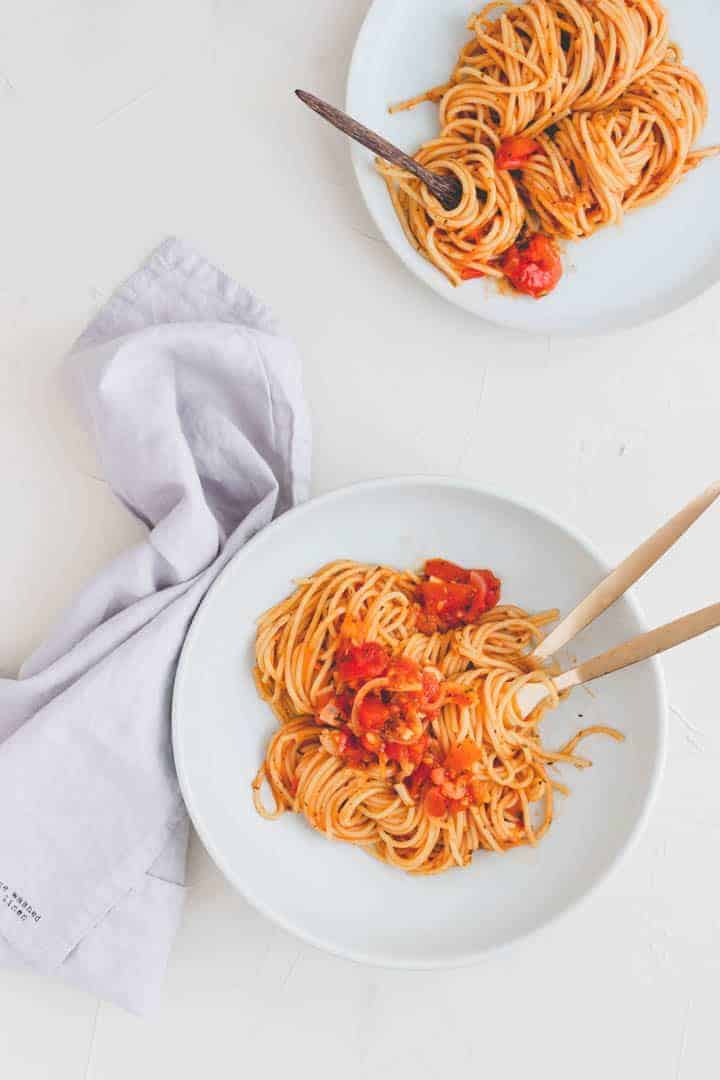 one pot pasta rezept serviert in zwei blauen tellern mit goldigem besteck