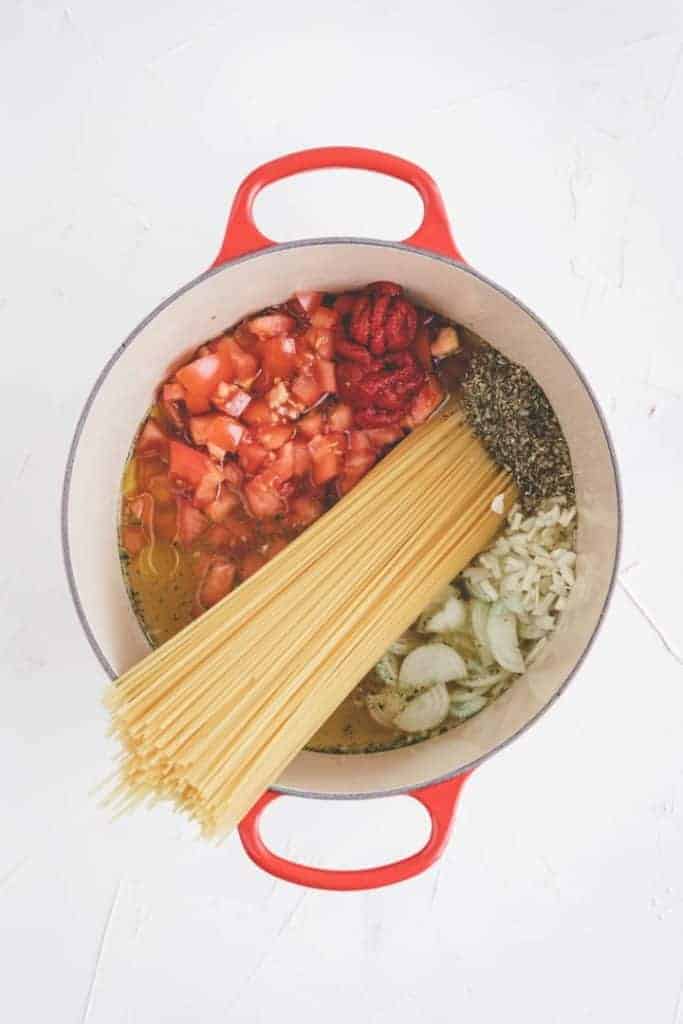 one pot pasta zutaten in einem roten kochtopf