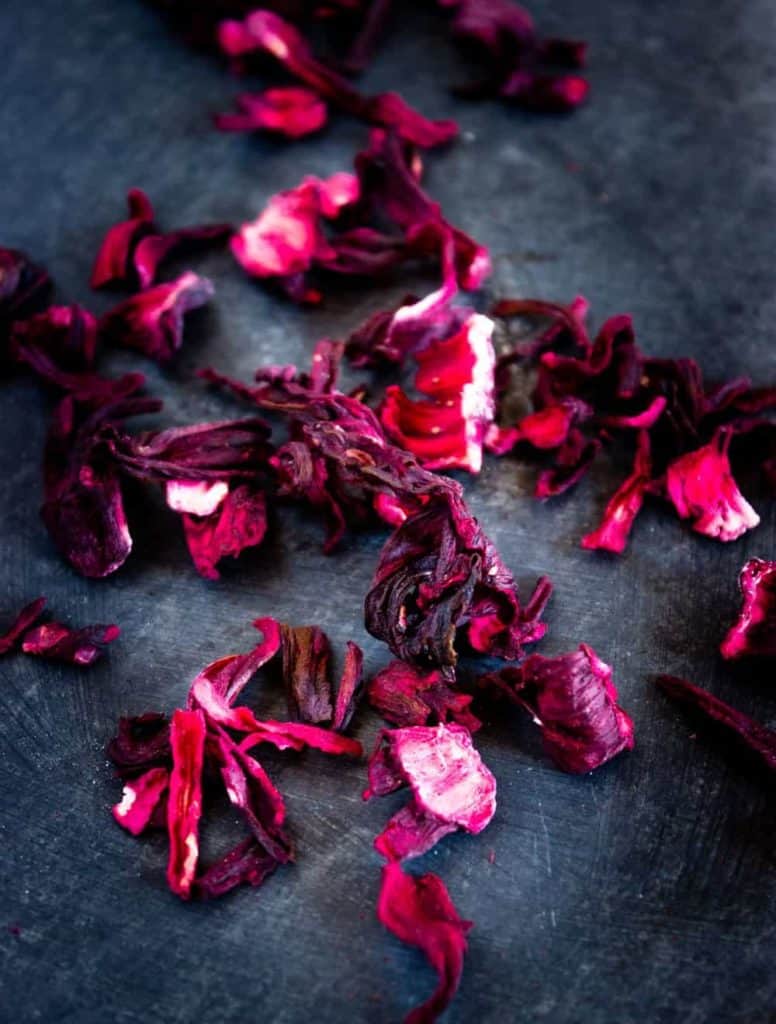getrocknete hibiskusblüten auf einem schwarzen brett
