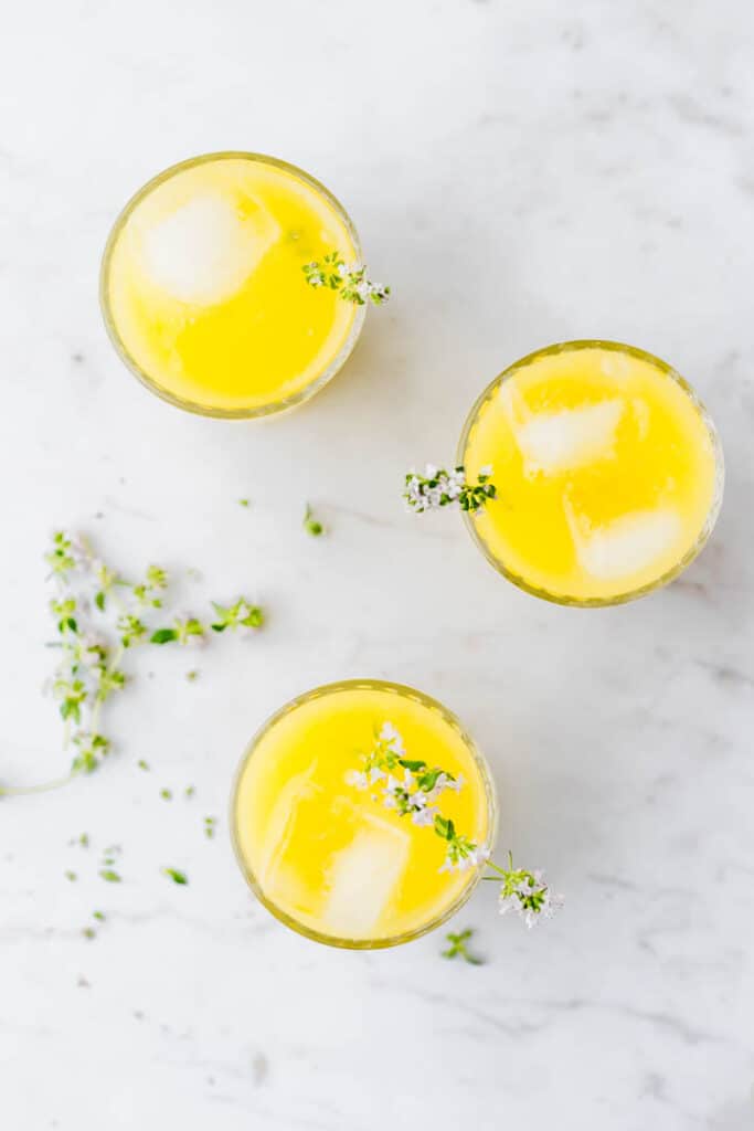 mango lemonade served in glasses on a marble table