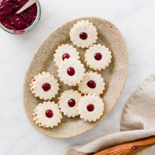 vegan linzer cookies served on a brown plate