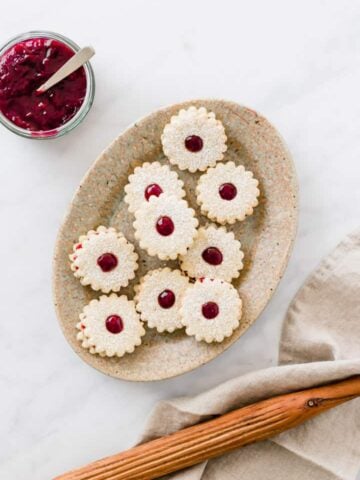 vegan linzer cookies served on a brown plate