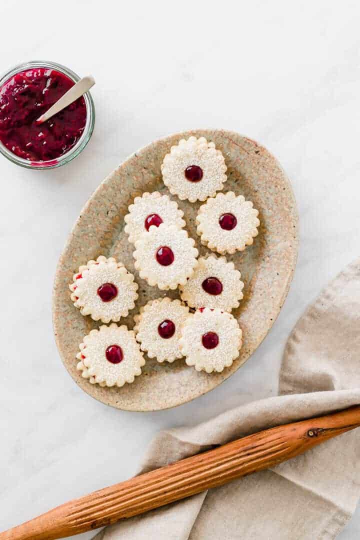 vegan linzer cookies served on a brown plate