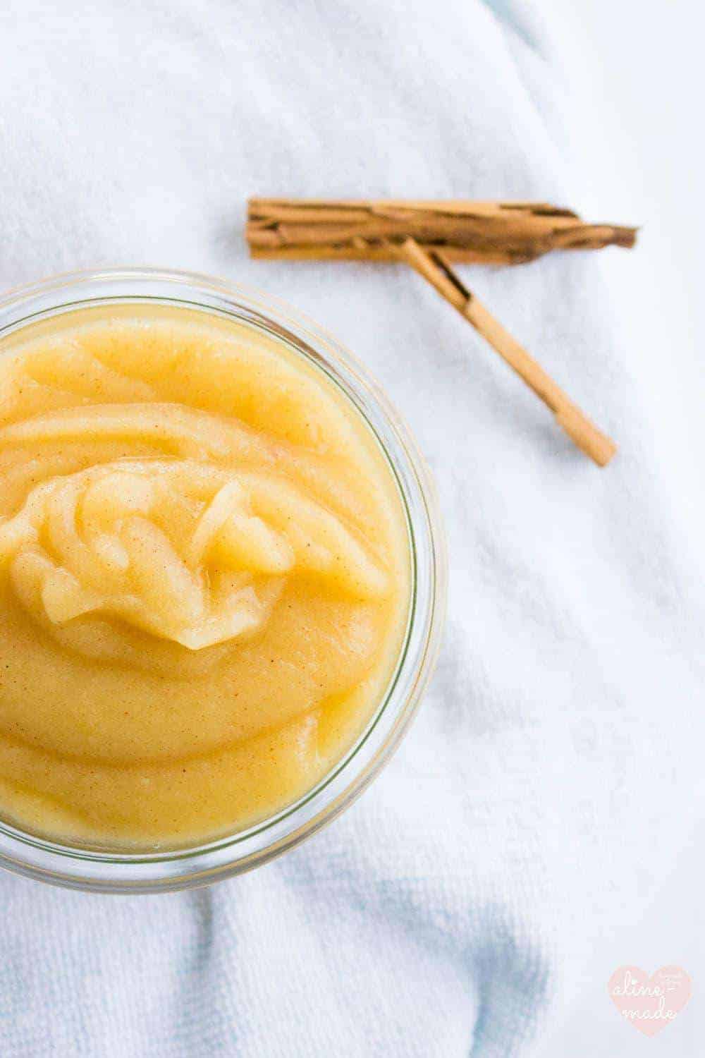 Homemade Applesauce in a glass jar with a cinnamon stick