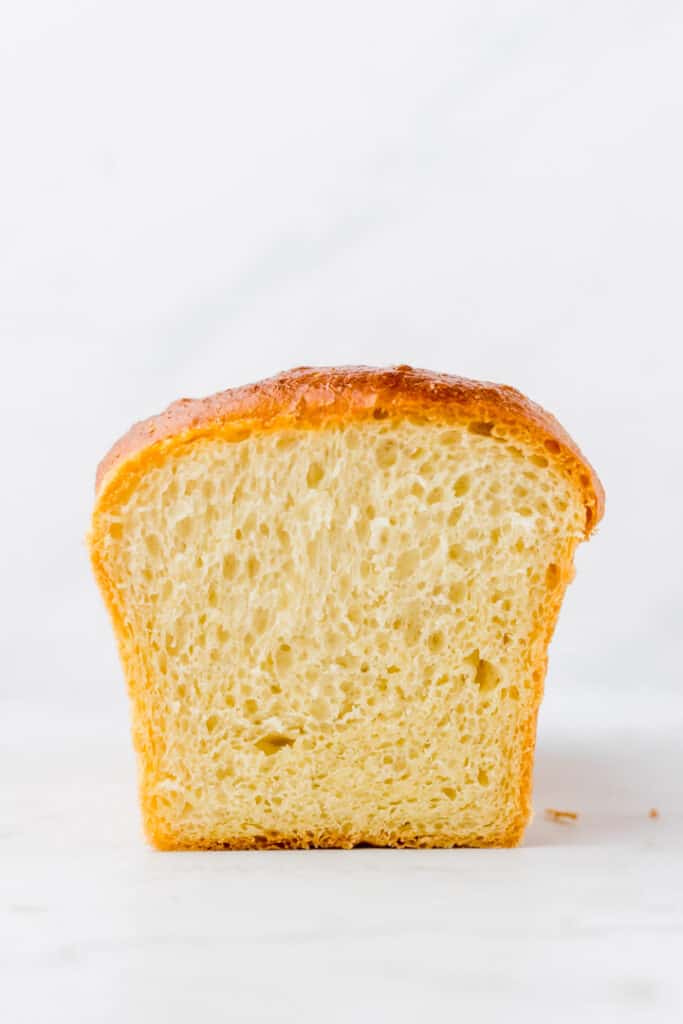 angeschnittenes Brioche von vorne fotografiert auf einem weissen Tisch