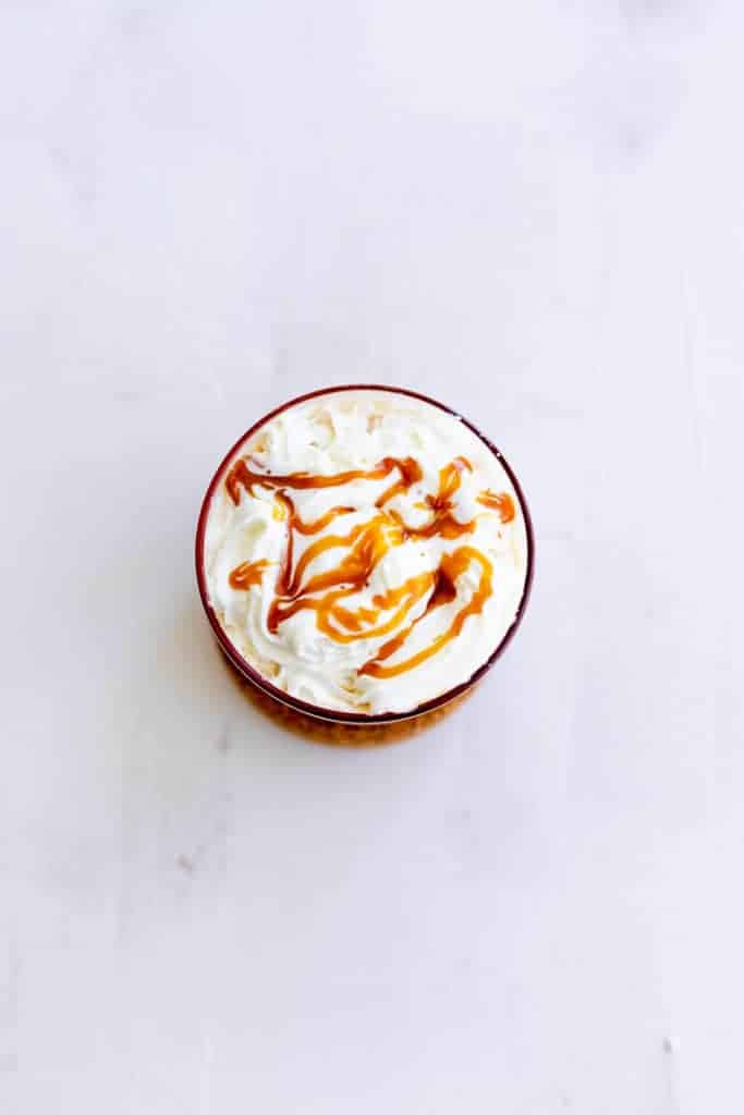 iced vanilla latte recipe topped with whipped cream and salted caramel sauce