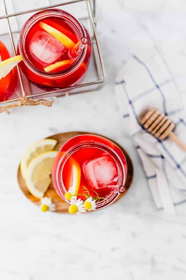 roter eistee serviert in einem glas mit eiswüfeln und zitrone