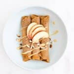 gluten-free buckwheat crepes topped with almonds, almond butter, and nectarine wedges