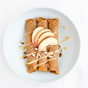 gluten-free buckwheat crepes topped with almonds, almond butter, and nectarine wedges