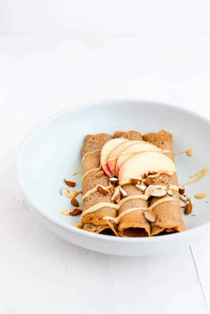 Buckwheat Crepes with Almond Butter served in a blue dish