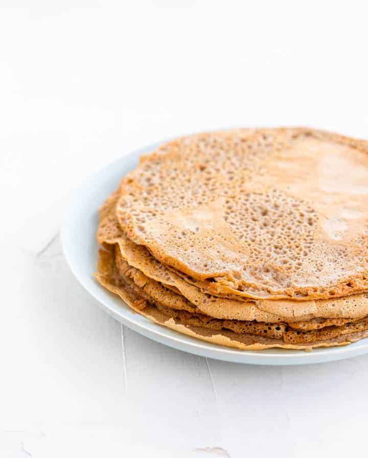 cooked buckwheat crepes on a blue plate