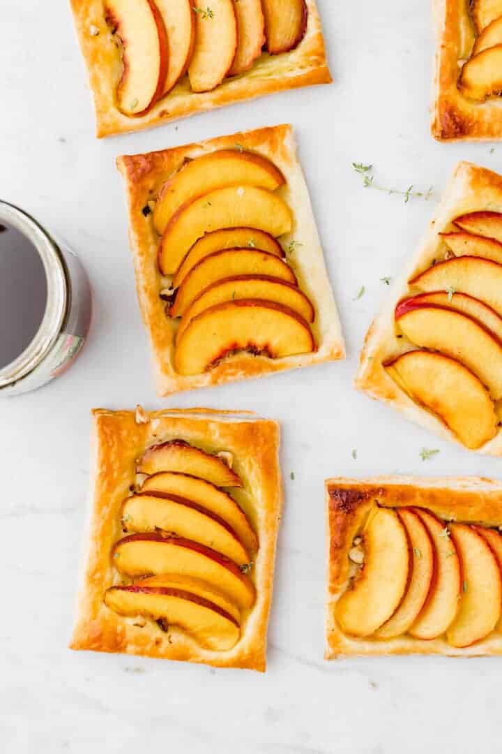 nectarine tarts next to a glass of maple syrup