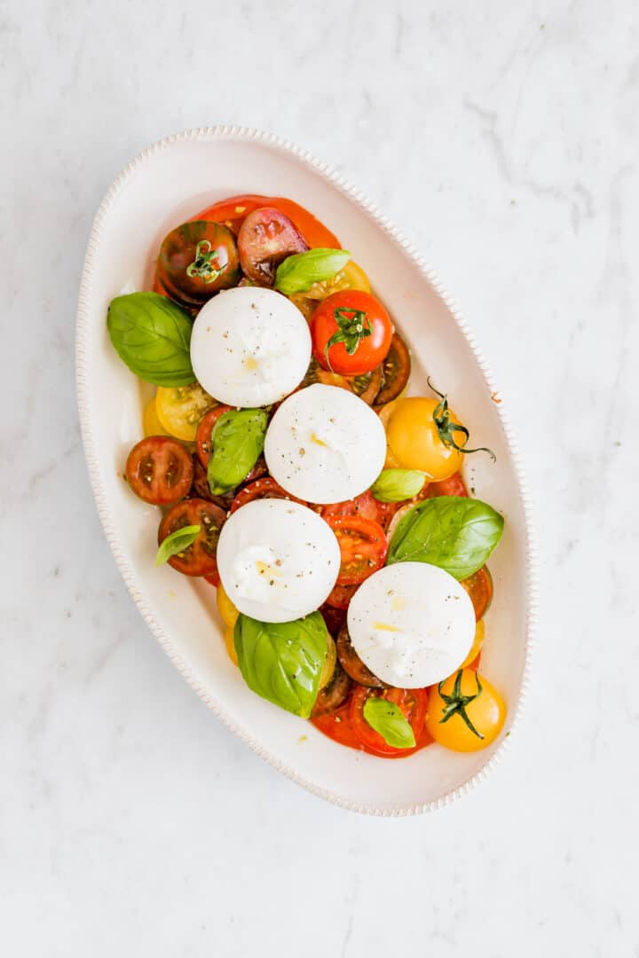 tomato burrata salad on a serving platter