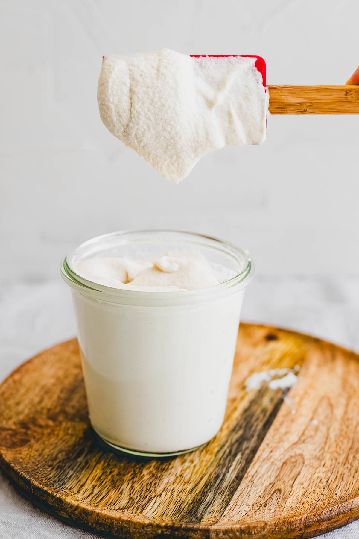 selbstgemachte cashew sahne in einem glas mit einem spachtel