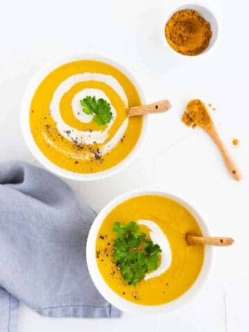 vegan potato soup served with vegan cream, curry powder, and greens