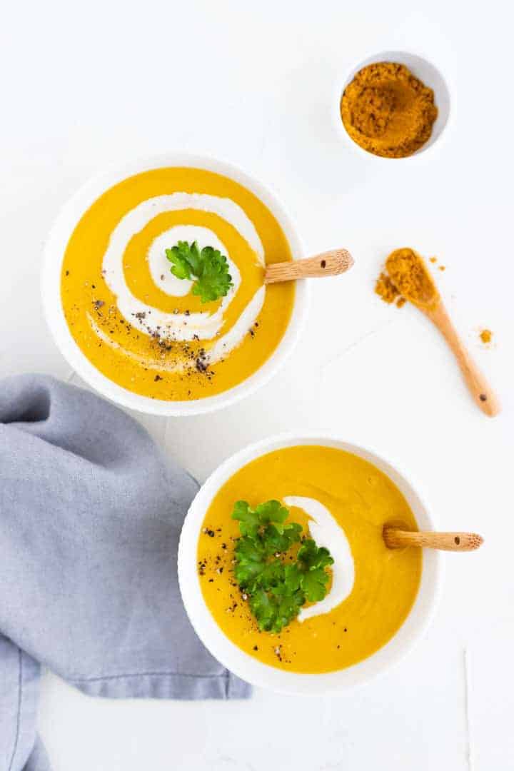 vegan potato soup served with vegan cream, curry powder, and greens