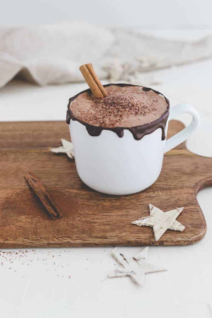 vegan hot chocolate with cinnamon on a wooden board