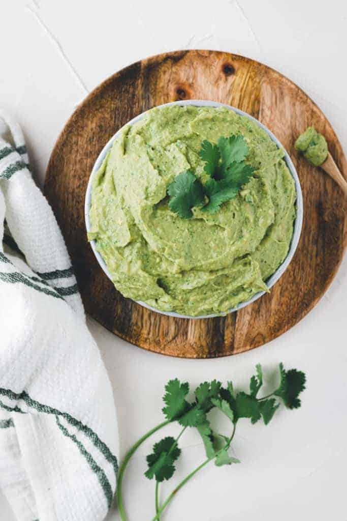 selbstgemachte guacamole in einer blauen schale mit koriander dekoriert