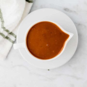 vegan gravy served in in a white saucier next to a towel