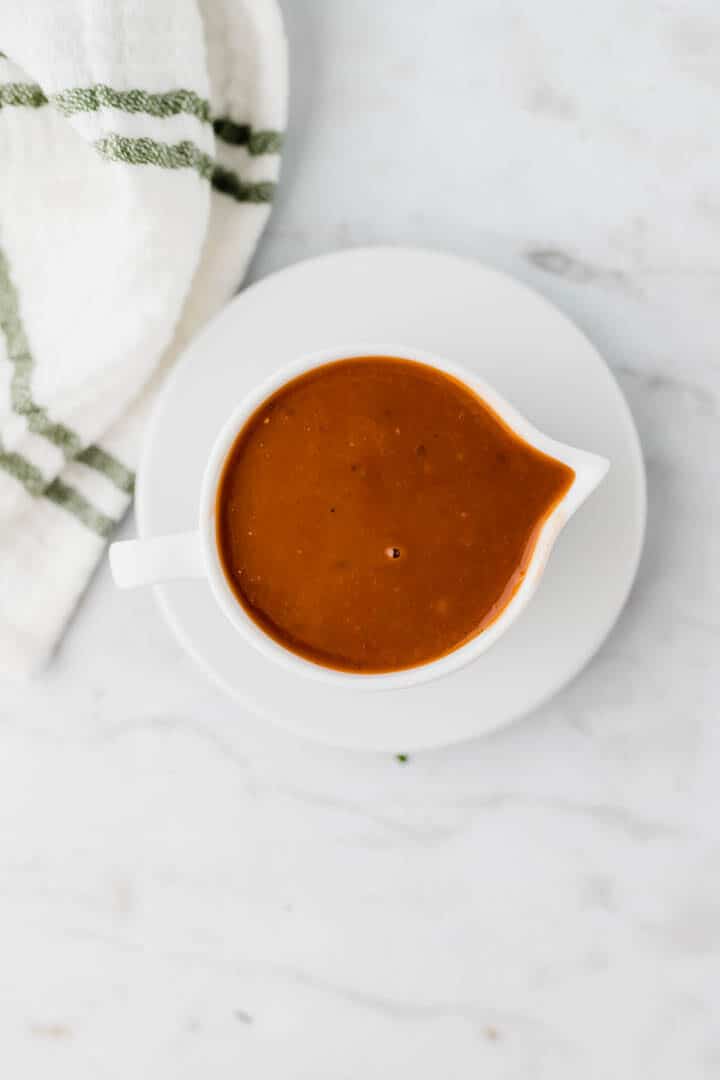 vegan gravy served in in a white saucier next to a towel