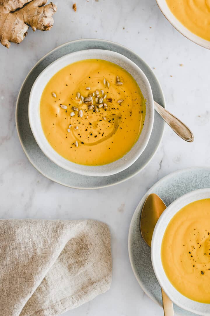 blue bowls filled with carrot soup
