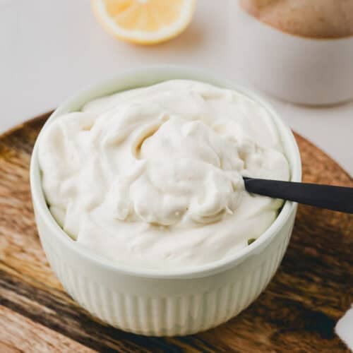 selbstgemachte vegane mayo in einer grünen schüssel mit einem schwarzen löffel