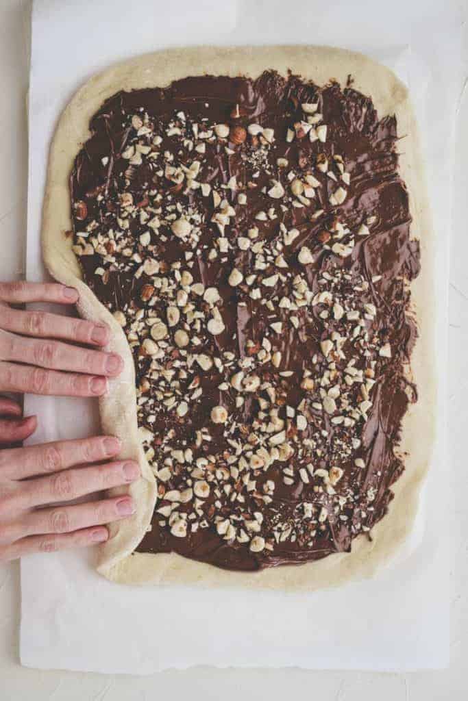 nutella zopf mit zwei händen am aufrollen