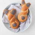 two easter bunny rolls on a blue napkin in a blue plate