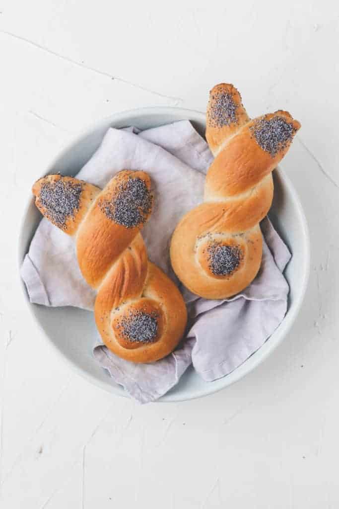 two easter bunny rolls on a blue napkin in a blue plate