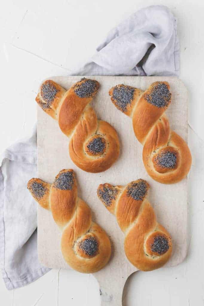 4 bunny dinner rolls on a white cutting board