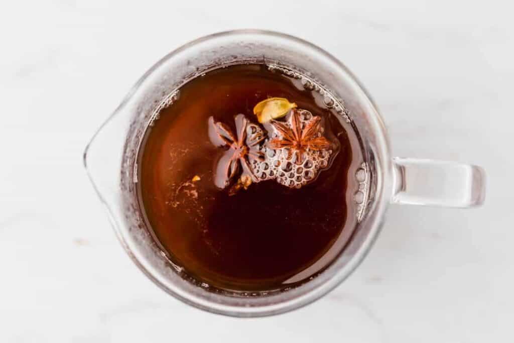 boiled black tea with start anise, cardamom, and cloves in a glass bottle