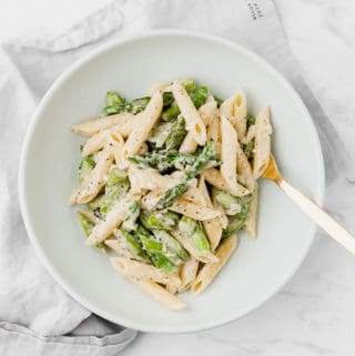 creamy asparagus pasta on a blue plate