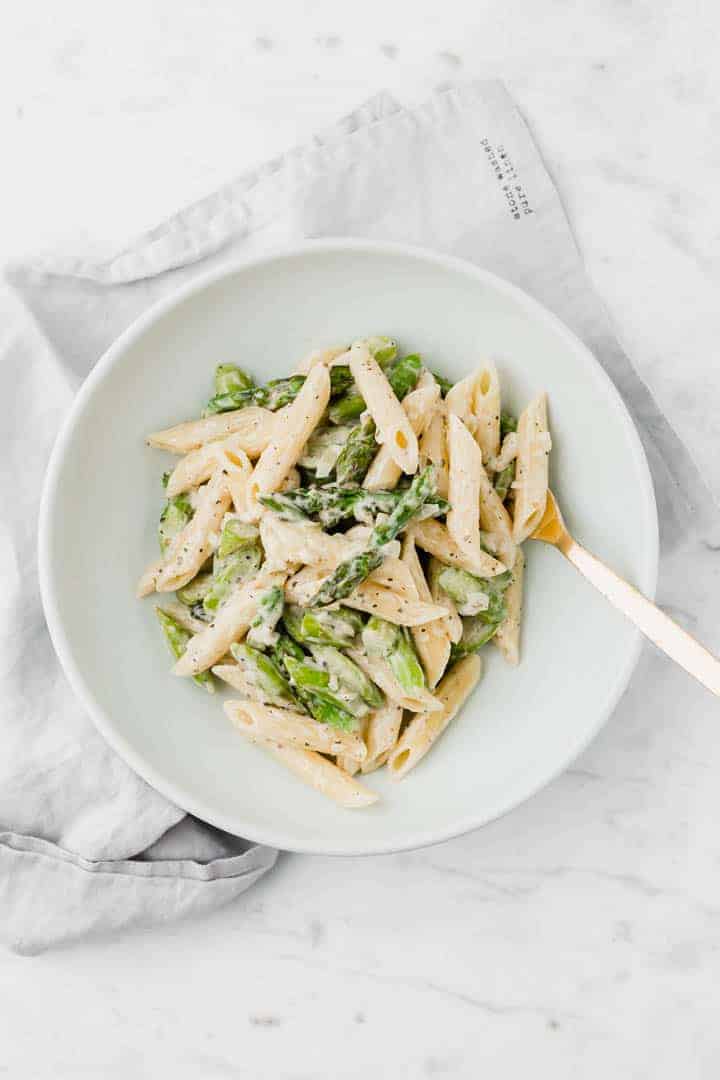 creamy asparagus pasta on a blue plate