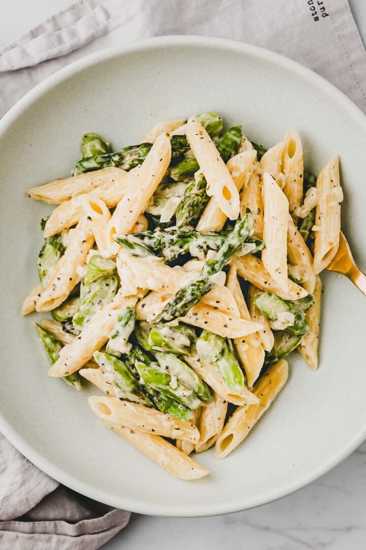 pasta mit grünem spargel in einerm teller serviert