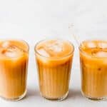 3 glasses of thai iced tea filled with iced cubes