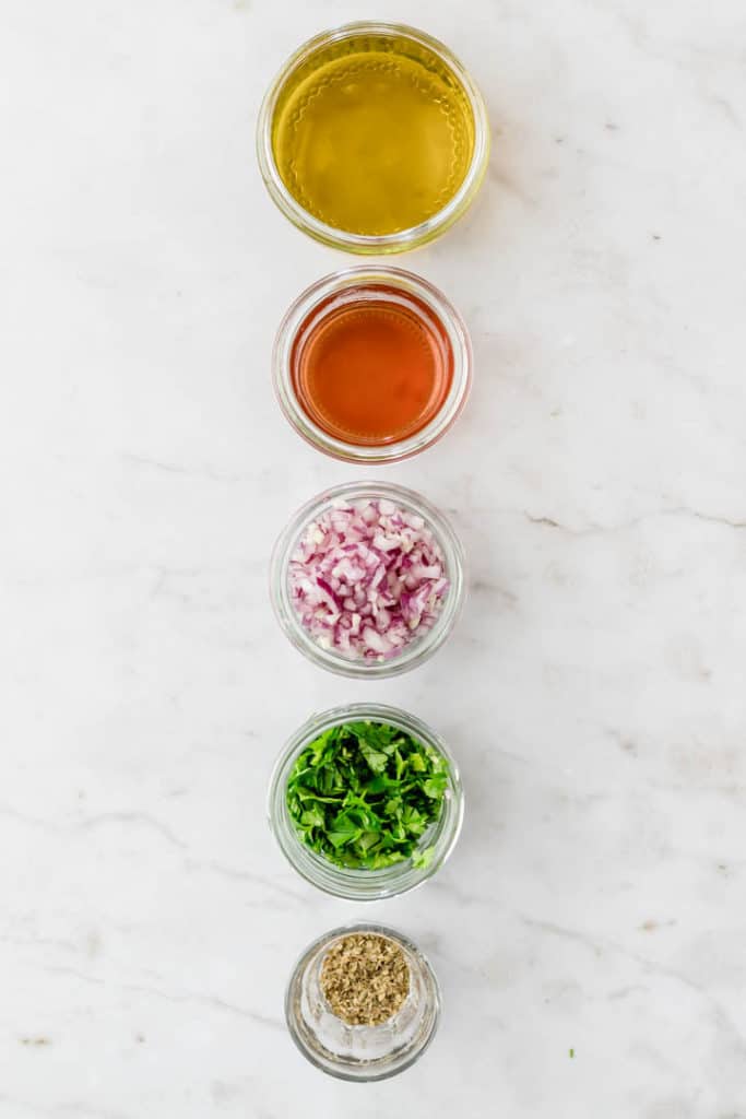 chimichurri ingredientes lined up on a white table