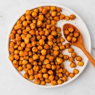 oven roasted chickpeas on a white plate with a wooden spoon