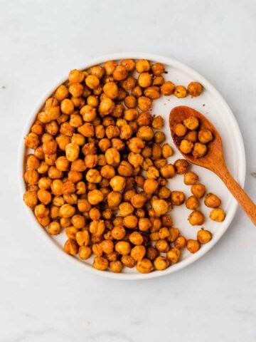 oven roasted chickpeas on a white plate with a wooden spoon