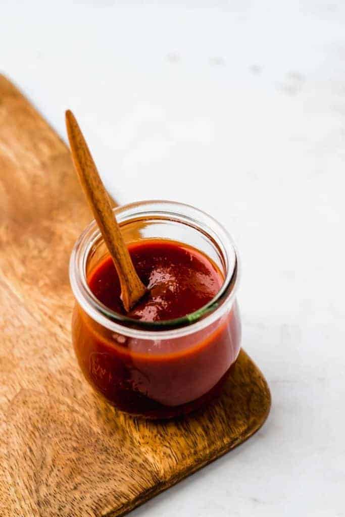 vegan barbecue sauce in a jar on a woodenboard