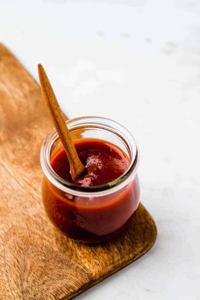 selbstgemachte barbecue sauce in einem weck glas auf einem holzbrett