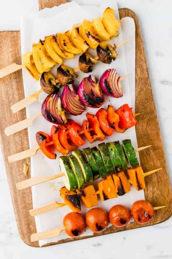 grilled veggie skewers served on a wooden plate