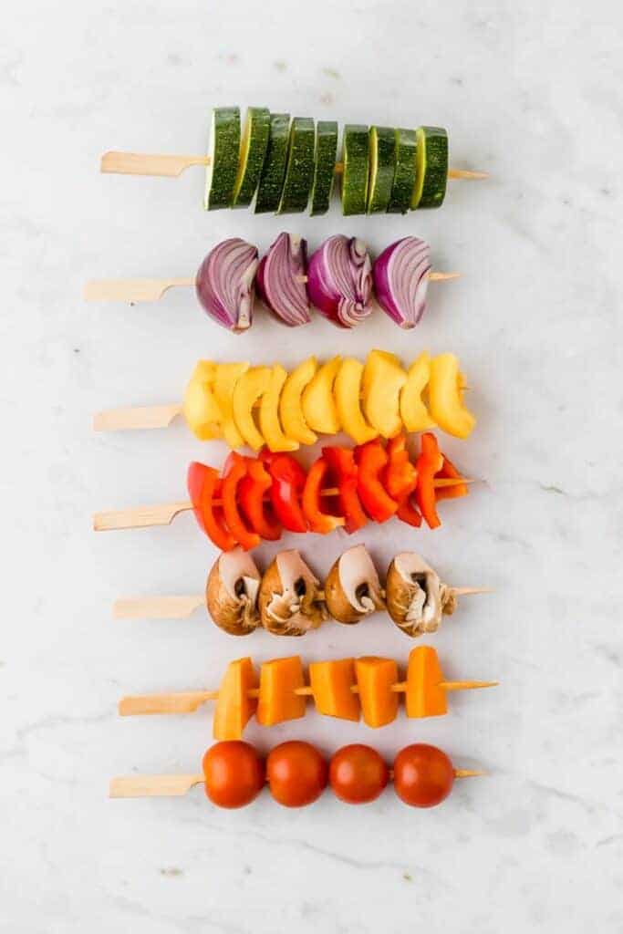 mixed raw vegetables on wooden skewers