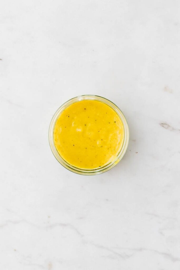 yellow veggie marinade in a glass jar on a marble dish