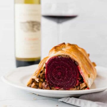 veganes beet wellington serviert mit einer flasche rotwein