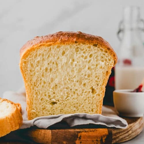 fertig gebackenes brioche brot angeschnitten auf einem holzbrett