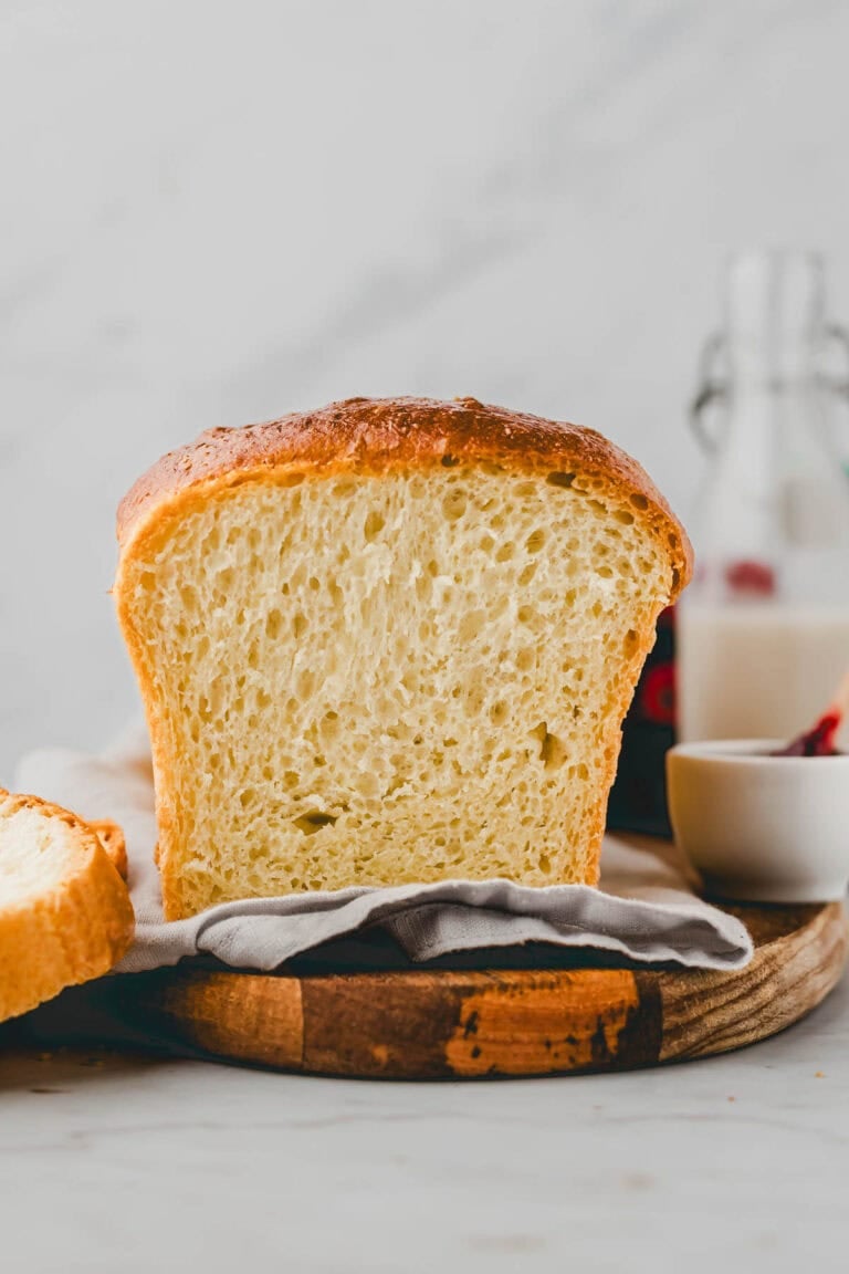 fertig gebackenes brioche brot angeschnitten auf einem holzbrett
